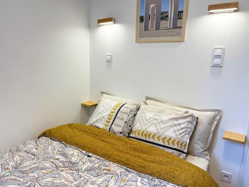 une chambre avec un lit avec des oreillers dessus dans l'établissement F2 ciel étoilé, au Havre