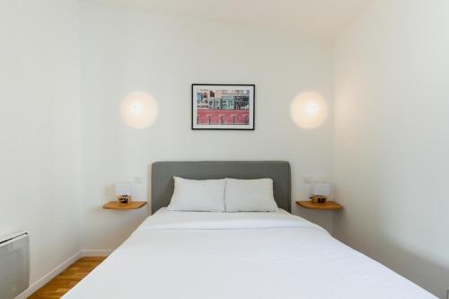 une chambre avec un lit et deux tables de nuit dans l'établissement Brand New - Exquisite and Sunny Parisian Loft, à Paris