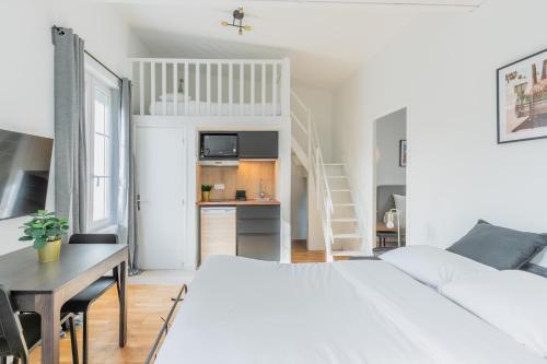 une chambre blanche avec un lit, un bureau et un escalier dans l'établissement Brand New - Exquisite and Sunny Parisian Loft, à Paris