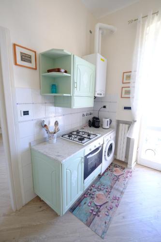 a kitchen with green cabinets and a stove top oven at La casa di sotto by PortofinoVacanze in Camogli