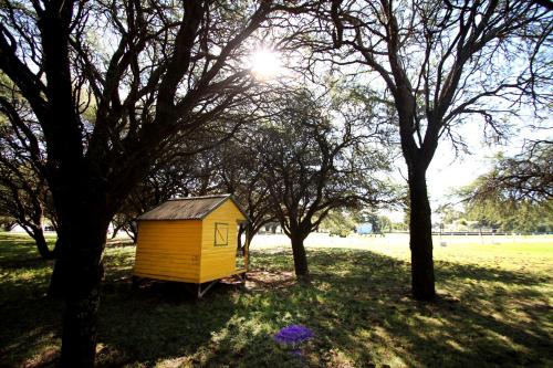a small yellow house in the middle of trees at La Campiña Club Hotel & Spa in Santa Rosa