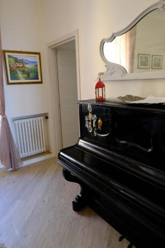 a black piano in a room with a mirror at La casa di sotto by PortofinoVacanze in Camogli