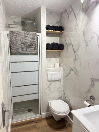 une salle de bain blanche avec toilettes et douche dans l'établissement Appartement Confort-Terrasse-Parking-Wifi-Cap d'agde, au Cap d'Agde