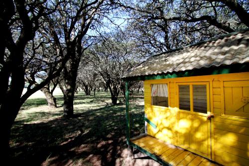 a small yellow building with a window next to trees at La Campiña Club Hotel & Spa in Santa Rosa