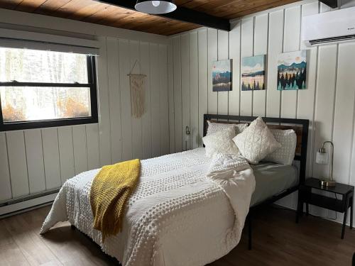 a bedroom with a bed with white sheets and pillows at Cozy Cottage 1 Block Walk From Lake Naomi - Poconos Pennsylvania Area 2 hours from New York City or Philadelphia - Pets Welcome - Check Minimum Night Requirement in Pocono Pines