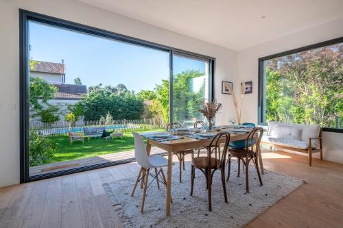 une salle à manger avec une table et des chaises et une grande fenêtre dans l'établissement Villa Mont d'or - Welkeys, à Champagne-au-Mont-dʼOr