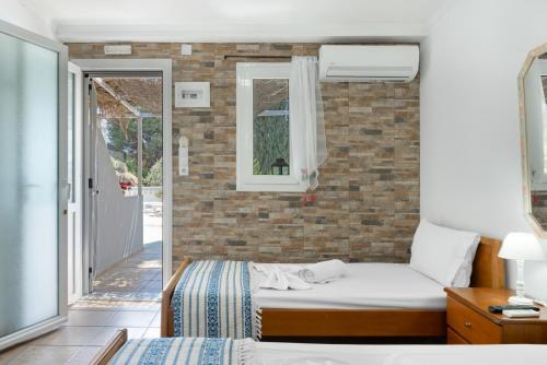 a bedroom with a bed and a brick wall at Ilias Studios Sevasti Kalymnos in Panormos Kalymnos