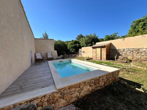- une piscine avec une terrasse en bois à côté d'un bâtiment dans l'établissement La Maison Hulotte, à Sagriès