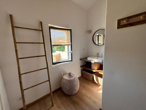 La salle de bains est pourvue d'une échelle et d'un lavabo. dans l'établissement La Maison Hulotte, à Sagriès