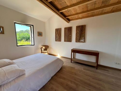 une chambre avec un lit, un bureau et une fenêtre dans l'établissement La Maison Hulotte, à Sagriès