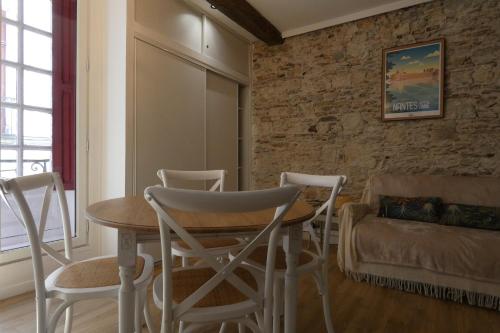 une pièce avec une table, des chaises et un canapé dans l'établissement petit chateau rouge - Hypercentre - rénové, à Nantes