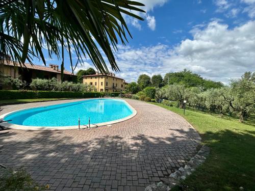 a swimming pool in a yard with a house in the background at La Vacanzella in Ponti Sul Mincio