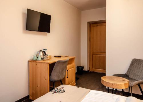 a room with a bed and a desk and a tv at Pienińska Ostoja in Czorsztyn