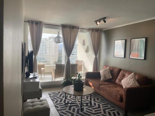 a living room with a couch and a large window at departamento con vista al mar en La Serena in La Serena