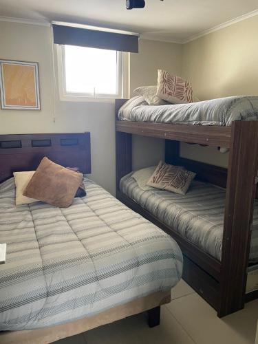 a bedroom with two bunk beds and a window at departamento con vista al mar en La Serena in La Serena