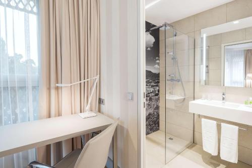 a bathroom with a sink and a shower at NH Graz City in Graz