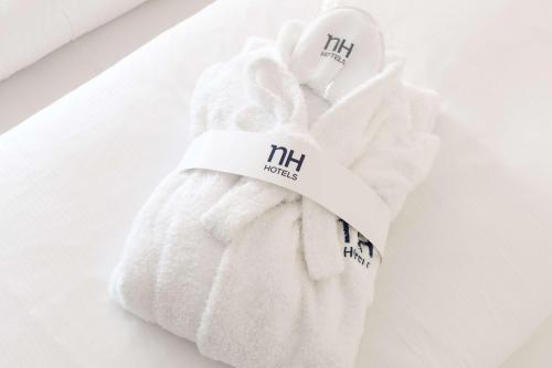 a white towel with the wordhm on it at NH Graz City in Graz