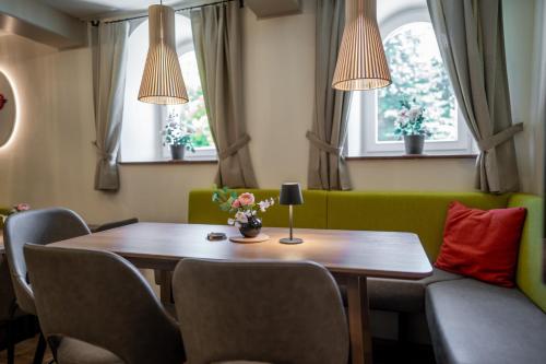 a dining room with a table and chairs and windows at Johannes Schlössl - Gästehaus der Pallottiner am Mönchsberg in Salzburg