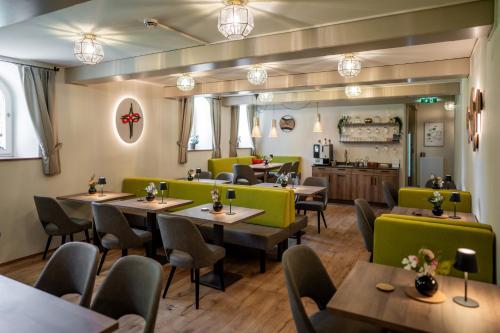 a restaurant with wooden tables and green chairs at Johannes Schlössl - Gästehaus der Pallottiner am Mönchsberg in Salzburg