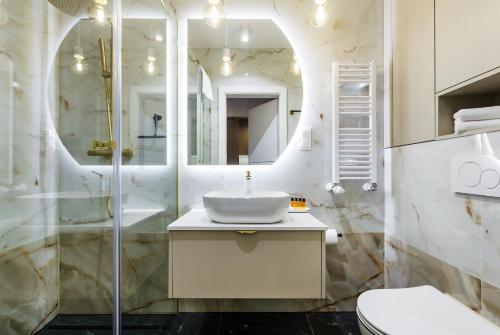 un bagno bianco con lavandino e doccia di Amber Elegance Stegna w Apartamentach Bursztynowych a Stegna