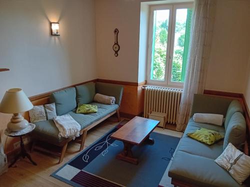 un salon avec deux canapés et une table dans l'établissement Maison de charme à la campagne, à Espagnac