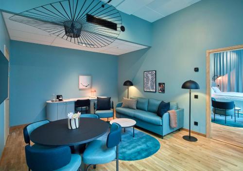 a blue living room with a blue couch and a table at Scandic Göteborg Central in Gothenburg