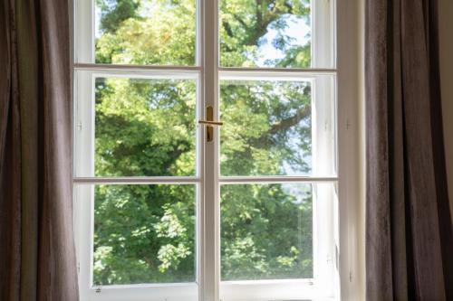 a window with a view of trees at Johannes Schlössl - Gästehaus der Pallottiner am Mönchsberg in Salzburg