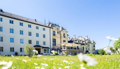 a group of buildings with a field of flowers at Johannes Schlössl - Gästehaus der Pallottiner am Mönchsberg in Salzburg