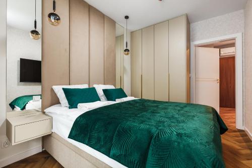 una camera da letto con un piumone verde su un letto di Amber Elegance Stegna w Apartamentach Bursztynowych a Stegna
