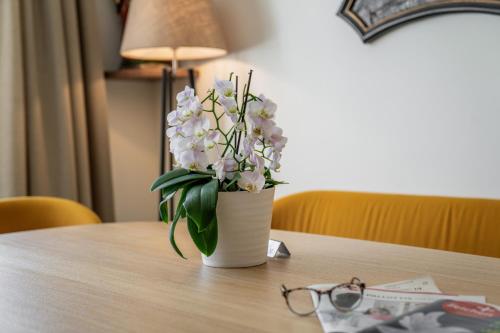 a white vase with white flowers on a table at Johannes Schlössl - Gästehaus der Pallottiner am Mönchsberg in Salzburg