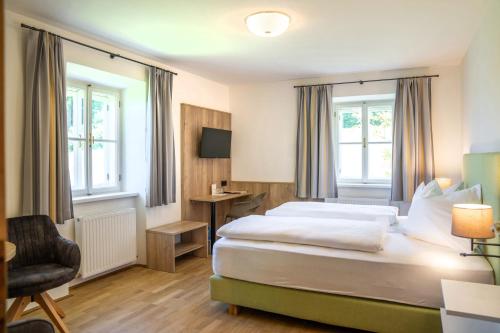 a hotel room with a bed and a chair at Johannes Schlössl - Gästehaus der Pallottiner am Mönchsberg in Salzburg