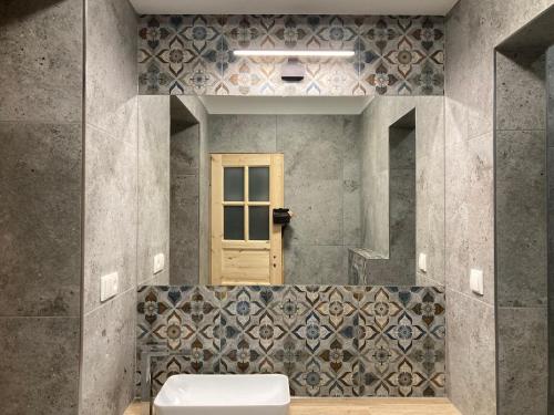 a bathroom with a sink and a window and a door at Pensjonat Halicz in Karpacz