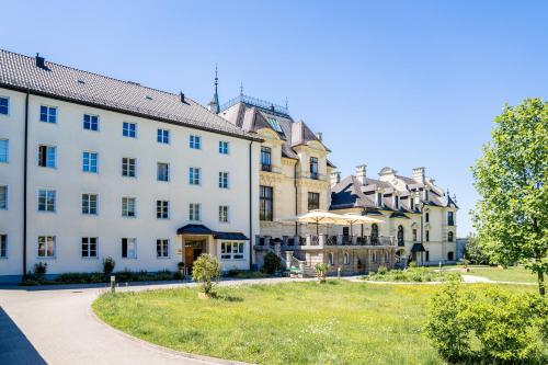 a large white building with a lawn in front of it at Johannes Schlössl - Gästehaus der Pallottiner am Mönchsberg in Salzburg