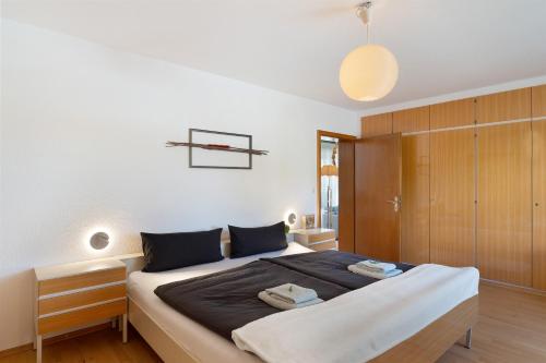 a bedroom with a large bed and a wooden cabinet at Ferien Am Weinberg in Kappelrodeck