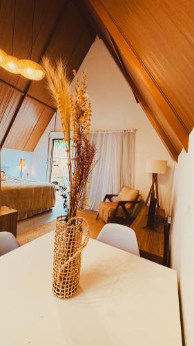 a room with a table with a vase with flowers on it at Cabana Gameleira - Viagem Inspirada in Fernando de Noronha