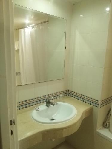 a bathroom with a sink and a mirror at Hotel Les Citronniers Hammamet in Hammamet