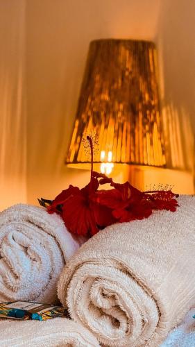 a room with two towels and a lamp with a lamp at Cabana Gameleira - Viagem Inspirada in Fernando de Noronha
