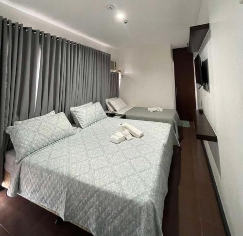 a hotel room with two beds with towels on them at Miran Hotel in Legazpi