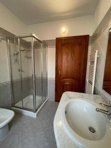 a bathroom with a shower and a sink and a toilet at Appartamento Gallospot in San Teodoro