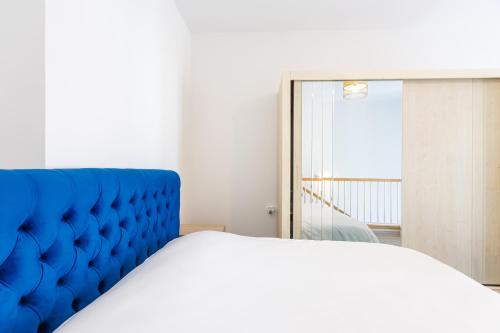 a bedroom with a blue bed and a mirror at Magnificent Diamond Duplex in Tbilisi City