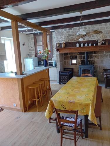 Il dispose d'une cuisine et d'un salon avec une table et une cheminée. dans l'établissement Maison de charme à la campagne, à Espagnac