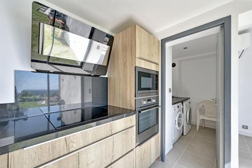 une cuisine avec un micro-ondes et un lave-linge et un sèche-linge dans l'établissement Villa Alta Vista avec Piscine, Clim, Vue, à Villeneuve-lès-Avignon