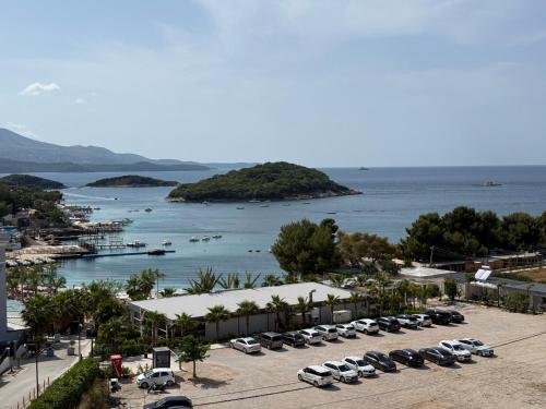 a parking lot with cars parked next to a body of water at Elio's Rooms in Ksamil