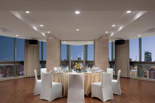 a dining room with a table and white chairs at Holiday Inn Shanghai Jing'an in Shanghai