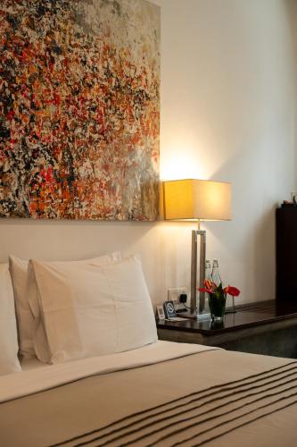 a bedroom with a bed and a painting on the wall at Nyne Hotels Lake Lodge - Colombo in Colombo
