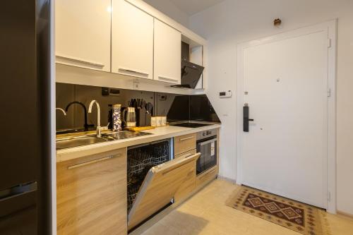 a kitchen with white cabinets and a sink at Magnificent Diamond Duplex in Tbilisi City