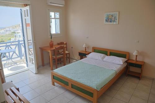a bedroom with a bed and a balcony at Athos Studios in Tinos Town