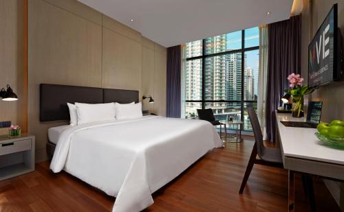 a bedroom with a large white bed and a desk at VE Hotel & Residence in Kuala Lumpur