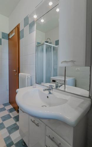 a bathroom with a white sink and a mirror at Casa Origine, appartamento vista piscina, al mare in Cavallino-Treporti