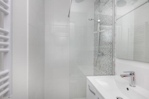 une salle de bain blanche avec un lavabo et une douche dans l'établissement Fée Viviane, à Brest